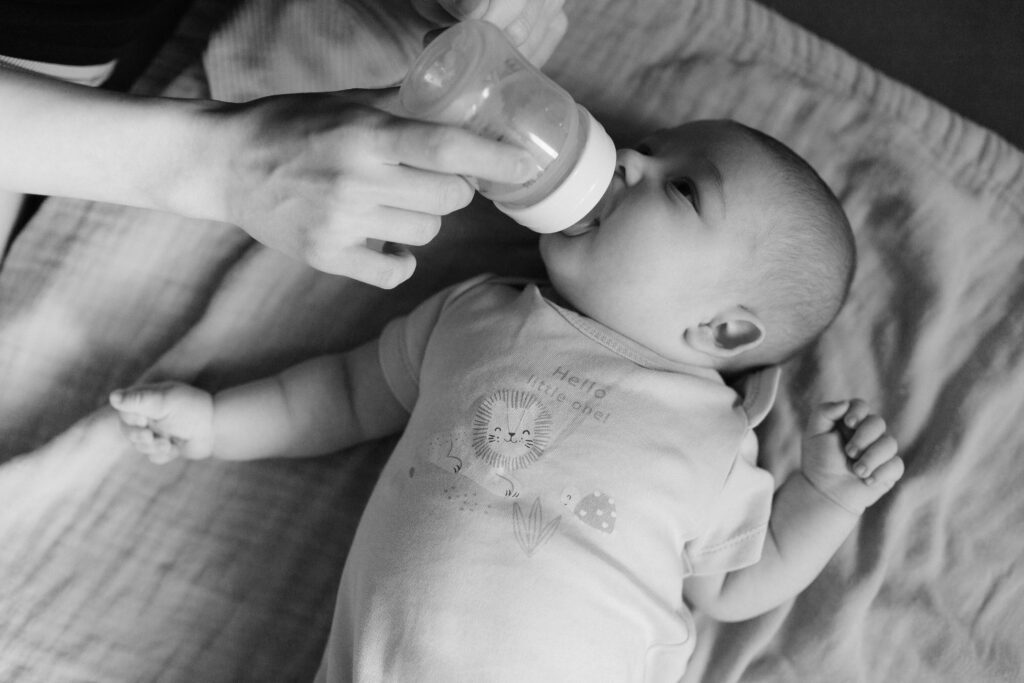 bottle feeding baby laying on crib